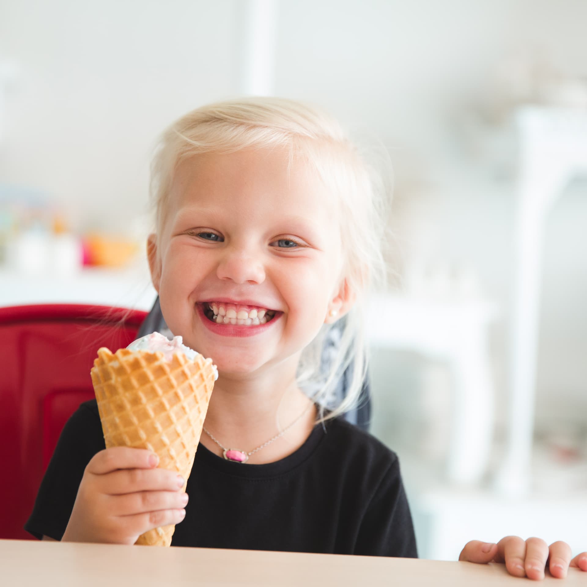 A smiling child enjoying an ice cream cone at The Cherry on Top