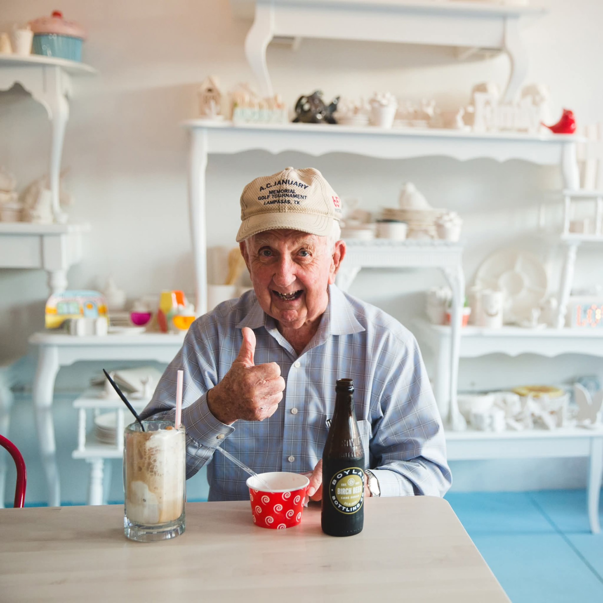 A happy guest giving a thumbs up over a root beer float and Boylan Birch Beer at the ice cream counter